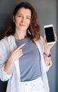 Pleased happy woman points at blank screen, shows modern device Royalty Free Stock Photo