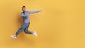 Look At This. Cherful asian man pointing aside while jumping in air Royalty Free Stock Photo