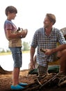 Look dad I chopped the wood myself. a young boy bringing firewood to his father while on a camping trip. Royalty Free Stock Photo