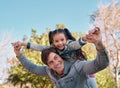 Look dad, Im flying. an adorable little girl enjoying a piggyback ride with her father at the park. Royalty Free Stock Photo