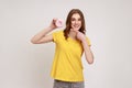 Look at donut. Portrait of cute teenager girl in yellow casual T-shirt pointing to doughnut and Royalty Free Stock Photo