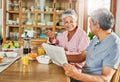 They look at each other the same way they always have. a carefree elderly couple having breakfast together while reading Royalty Free Stock Photo