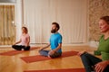 We look forward to time with ourselves on the mat. three people doing yoga together in a studio. Royalty Free Stock Photo