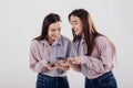 Look at this funny picture. Two sisters twins standing and posing in the studio with white background Royalty Free Stock Photo