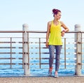 Young woman in fitness outfit looking aside at embankment Royalty Free Stock Photo