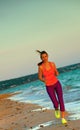 Healthy fit woman on seashore in evening running Royalty Free Stock Photo