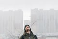 Look into the gray sky and gloomy. Vertical. A man looking up against the background of houses. Place for your text Royalty Free Stock Photo