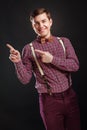 Look at this! Handsome young scientific man in vintage shirt bow tie pointing copy space and smiling while standing against black Royalty Free Stock Photo