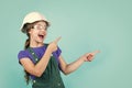 Look here. Little girl in hard hat play in workshop. Child protection and safety. Little smiling builder in helmet