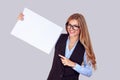 Look here on my paper. Happy smiling young business woman showing blank signboard, paper card isolated light purple violet white