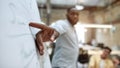 Look here. Young afro american businessman pointing at white blackboard and explaining something to his colleagues Royalty Free Stock Photo