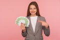 Look, I am rich! Portrait of millionaire, elegant wealthy woman in suit holding euro banknotes and smiling