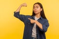 Look, I am strong! Portrait of confident proud girl in denim shirt pointing at biceps, expressing power ambitions Royalty Free Stock Photo