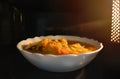 Look inside the microwave food white bowl, In a warm atmosphere and empty top space for text. Spicy food.