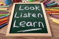 Look, Listen, Learn basic education concept, school desk, blackboard