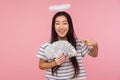 Look at my money! Portrait of glad angelic girl with halo over head pointing at dollars and smiling Royalty Free Stock Photo