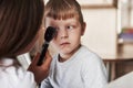 Look straight. Boy have eye test with special little device. Concentrating on sight health