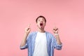 Look there, crazy news! Portrait of shocked brunette man pointing up at copy space. indoor isolated on pink background Royalty Free Stock Photo