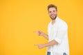 Look there. Man pointing at copy space. Check this out. Man muscular handsome smiling unshaven guy on yellow background Royalty Free Stock Photo