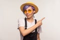 Look there! Portrait of glamour wondered hipster girl with violet hair in sunglasses and hat pointing to the side. studio shot Royalty Free Stock Photo