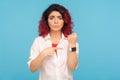 Look at the time! Displeased woman with fancy red hair showing wrist watch to remind of late hour Royalty Free Stock Photo