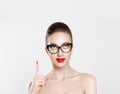 Look up here. Closeup brunette smart young woman pretty smiling girl in eye glasses nude makeup red lips idea looking up pointing Royalty Free Stock Photo