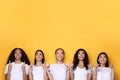 Five Multiethnic Women Pointing Fingers Up Posing Over Yellow Background Royalty Free Stock Photo