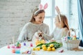 Look what a cute rabbit.The little daughter with her mother stroke a home decorative rabbit