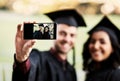 Look who just graduated. two students taking a selfie together on graduation day. Royalty Free Stock Photo