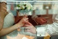 A look through the window on the hands of newlyweds holding a we