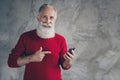 Look x-mas discounts. Happy modern old man use smart phone get notification direct newyear tradition greetings wear red Royalty Free Stock Photo