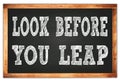 LOOK BEFORE YOU LEAP words on black wooden frame school blackboard Royalty Free Stock Photo