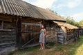 LookBook portrait of a girl in a rustic vintage dress with rakes near a rural barn and cowshed in a courtyard Royalty Free Stock Photo