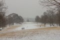 Looking across a snow covered wide open space in a park in urban Atlanta during winter