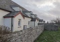 Looking along an old wall at a row of cottages Royalty Free Stock Photo