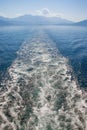 Looking back to the far shore. Wave pattern on the water surface behind boat