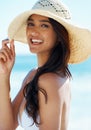 Looking beach ready. A gorgeous young woman wearing a sunhat on the beach.