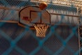 Looking through a blue fence to an indoor basketball court with a basketball about to score a basket