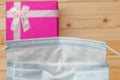 Looking through a blue surgical mask on a small rectangular present gift box on a table