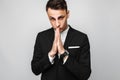 Looking businessman praying. A young guy in a black suit holding Royalty Free Stock Photo