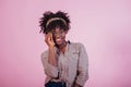 Looking into the camera. Trying on new glasses. Attractive afro american woman in casual clothes at pink background in Royalty Free Stock Photo