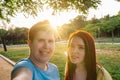 looking at the camera two great friends taking a selfie, in a public park in the city at sunset. young girls enjoying Royalty Free Stock Photo