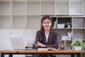 Looking camera. Young Attractive Asian female lawyer working in office with contract and law books when sitting at desk Royalty Free Stock Photo