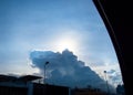 Looking through car window at Sun behind cloud on road in evening