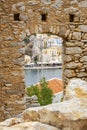 Looking at Colorful Symi Houses Across the Harbor Through a Glassless Window of an Old Ruin Royalty Free Stock Photo