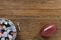 Looking down on an American football with a tub of assorted ice cold beer bottles on a wooden table Royalty Free Stock Photo