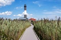 Looking down the boardwalk at the Fire Island Lighthouse surrounded by tall beach grass Royalty Free Stock Photo