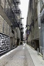 Looking down a city Alley Road with graffiti on walls brick pavers old vintage Street an urban city setting Royalty Free Stock Photo