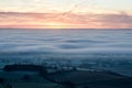 Looking down on fog and temperature inversion from the Malvern Hills. In the English countryside. With sunrise on a winters day. Royalty Free Stock Photo