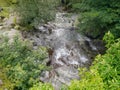 Looking down through foliage to small flowing river Royalty Free Stock Photo